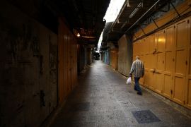 A man walks in an alley inside Jerusalem's Old CIty as shops are closed amid coronavirus restrictions in the walled Old City March 27, 2020 REUTERS/ Ammar Awad