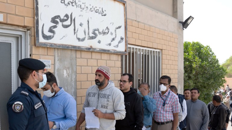 Expatriates are seen in line as they need to take a coronavirus clearance certificate, after returning from vacations, following the outbreak of the virus, at a health clinic in Subhan, Kuwait March 9, 2020. REUTERS/Stephanie McGehee