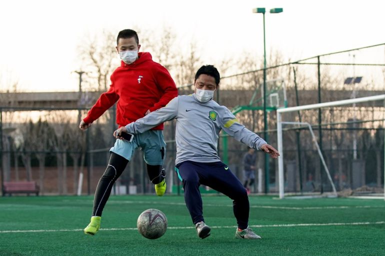 BEIJING, CHINA - FEBRUARY 29: Citizens wear a protective facemasks as they play football at a park in Beijing on February 29, 2020 in Beijing, China. The number of cases of a deadly new coronavirus rose to more than 79,000 in mainland China, and as of today, 2,873 patients have died. (Photo by Lintao Zhang/Getty Images)