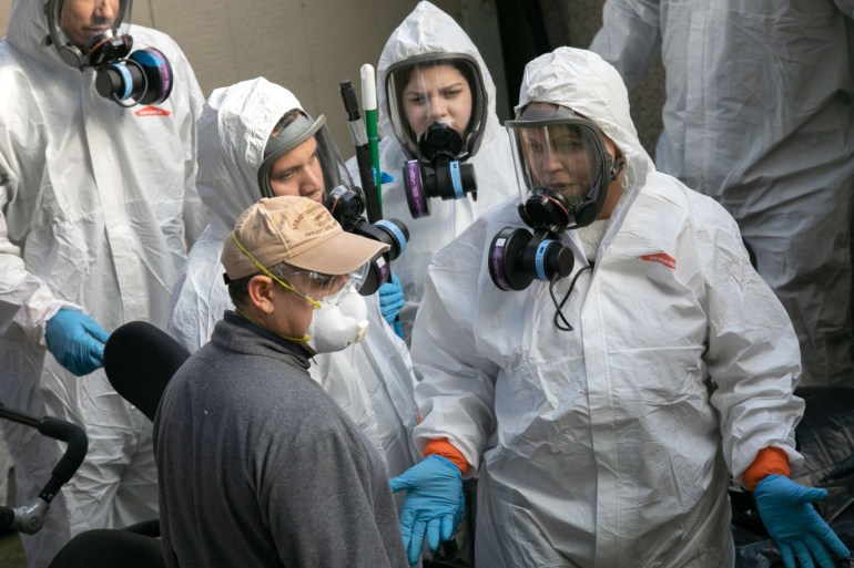KIRKLAND, WASHINGTON - MARCH 11: A cleaning crew exits the Life Care Center on March 11, 2020 in Kirkland, Washington. Most of the coronavirus deaths in Washington State have been linked to the nursing home. John Moore/Getty Images/AFP== FOR NEWSPAPERS, INTERNET, TELCOS & TELEVISION USE ONLY ==