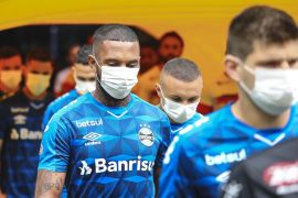 PORTO ALEGRE, BRAZIL - MARCH 15: Players of Gremio enter the field wearing masks before the match between Gremio and Sao Luiz as part of the Rio Grande do Sul State Championship 2020, to be played behind closed doors at Arena do Gremio Stadium, on March 15, 2020 in Porto Alegre, Brazil. The Government of the State of Rio Grande do Sul issued a list of new guidelines to help prevent the spread of the Coronavirus which included games played with closed doors and no public. According to the Ministry of Health, as of Saturday, March 14, Brazil had 121 confirmed cases of coronavirus. (Photo by Lucas Uebel/Getty Images)