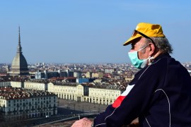A man wearing a protective face mask looks at downtown Turin from the Monte dei Cappuccini, on the fourth day of an unprecedented lockdown across of all Italy imposed to slow the outbreak of coronavirus, in Turin, Italy, March 13, 2020. REUTERS/Massimo Pinca