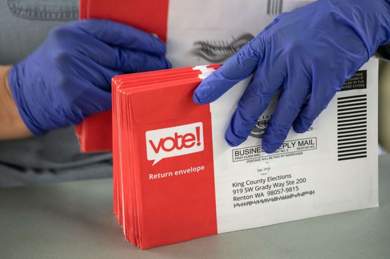 RENTON, WASHINGTON - MARCH 09: An election worker wearing protective gloves sorts through mailed-in ballots in the King County Elections ballot processing center on March 09, 2020 in Renton, Washington. Election officials mandated the precautionary measure for workers handling ballots in this year's primary election counting process. King County has had the highest number of deaths in the U.S. due to the coronavirus outbreak. John Moore/Getty Images/AFP== FOR NEWSPAPERS, INTERNET, TELCOS & TELEVISION USE ONLY ==