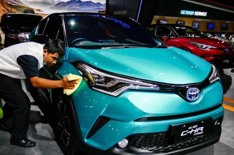 Indonesia International Motor Show 2019- - JAKARTA, INDONESIA - APRIL 25: A worker cleans the Toyota Hybrid CH-R on the Indonesia International Motor Show at international Expo in Jakarta, Indonesia on April 25, 2019. This automotive exhibition starts from 25 April to 5 May 2019 in Jakarta International Expo.