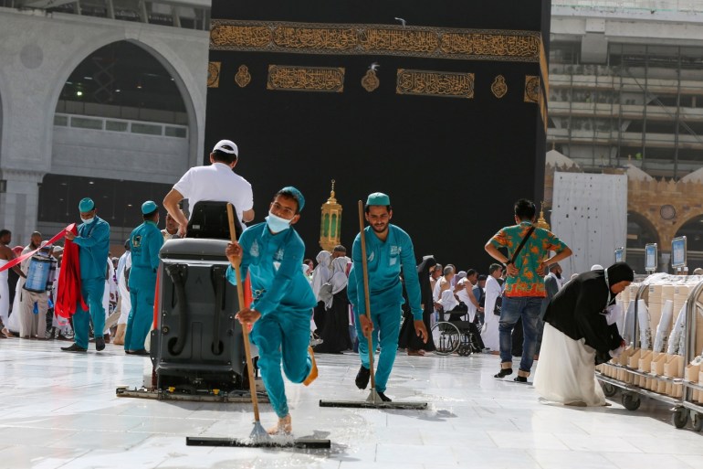 Cleaners wear protective face masks, following the outbreak of the coronavirus, as they swipe the floor at the Kaaba in the Grand mosque in the holy city of Mecca, Saudi Arabia March 3, 2020. REUTERS/Ganoo Essa