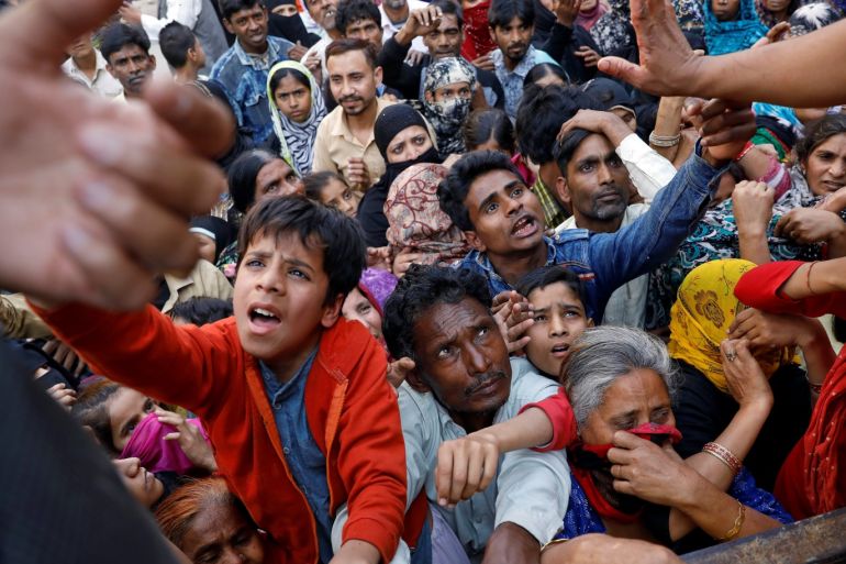 People crowd to receive free grocery items being distributed outside a relief camp after they fled their homes following Hindu-Muslim clashes triggered by a new citizenship law, in Mustafabad in the riot-affected northeast of New Delhi, India, March 3, 2020. Picture taken March 3, 2020. REUTERS/Anushree Fadnavis