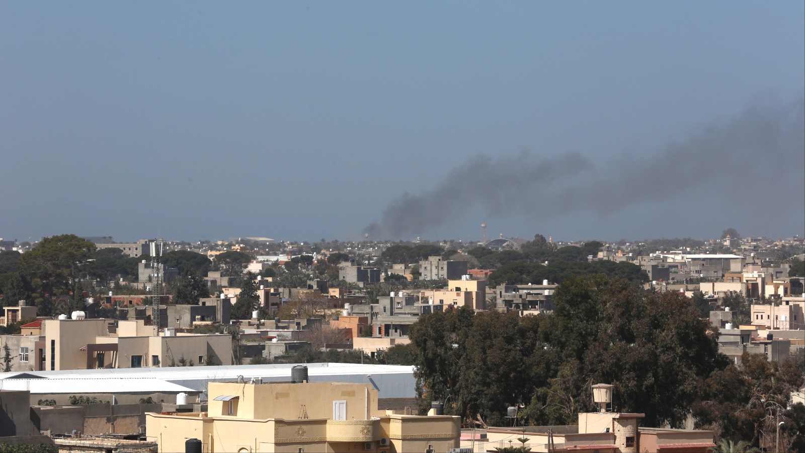 ‪(الأناضول)‬ دخان متصاعد جراء قصف سابق على مطار معيتيقة