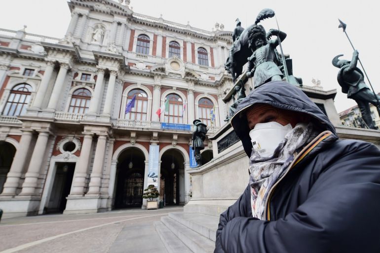 A woman wears a mask at the Carlo Alberto square, after the government decree to close cinemas, schools and urge people to work from home and not stand closer than one metre to each other, in Turin, Italy, March 5, 2020. REUTERS/Massimo Pinca