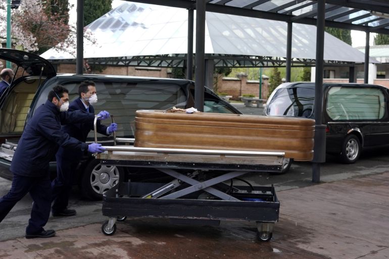 Employees of a mortuary enter the crematorium of La Almudena cemetery with a coffin of a person who died of coronavirus disease (COVID-19) during partial lockdown to combat the coronavirus disease (COVID-19) outbreak in Madrid, Spain, March 23, 2020. REUTERS/Juan Medina