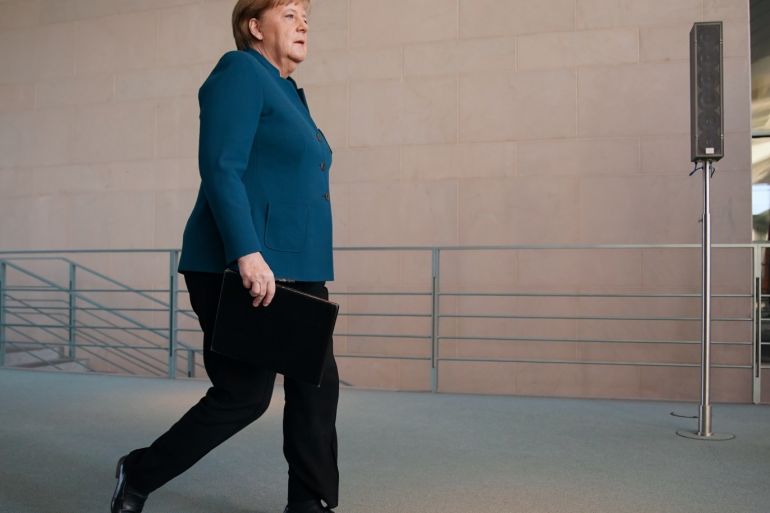 BERLIN, GERMANY - MARCH 22: German Chancellor Angela Merkel walks to speak to the media to announce further measures to combat the spread of the coronavirus and COVID-19, the disease the virus causes, after she held a teleconference with the governors of Germany's 16 states on March 22, 2020 in Berlin, Germany. Following her speech, Merkel went home to quarantine after a doctor she was in contact with tested positive for coronavirus. The Chancellor during her speech announced the country will ban gatherings of more than two people, with the exception of families and households, as a measure to combat the spread of the virus that has so far caused over 23,000 infections and 92 deaths. (Photo by Clemens Bilan - Pool/Getty Images)