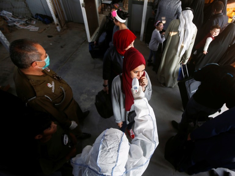 An Iraqi medical staff member checks a passenger's temperature, amid the new coronavirus outbreak, upon her arrival to Shalamcha Border Crossing between Iraq and Iran, February 20, 2020. REUTERS/Essam al-SudanI