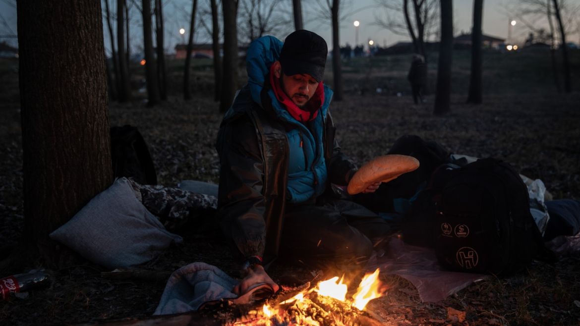 EDIRNE, TURKEY - MARCH 01: A refugee from Iraq toasts bread on his fire as he waits on the Turkish shoreline of the Evros River to  attempt to cross to Greece on March 01, 2020 in Edirne, Turkey. Thousands of refugees and migrants have flocked to the Greece, Turkey border after Turkey announced that it would open border gates for a period of 72hrs to allow refugees to cross into European countries after thirty three Turkish soldiers were killed in a Syrian air raid in I