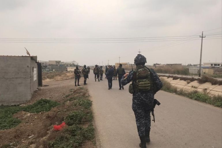 Iraqi security forces walk near a building where they found unused Katyusha rockets in Umm al-Izam, in this picture provided by Iraqi Media Security Cell, March 14, 2020. Iraqi Media Security Cell/Handout via REUTERS ATTENTION EDITORS - THIS IMAGE WAS PROVIDED BY A THIRD PARTY