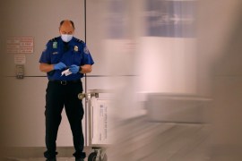 PHOENIX, ARIZONA - MARCH 12: A TSA agent looks at his cell phone while wearing a mask and gloves at Sky Harbor Airport on March 12, 2020 in Phoenix, Arizona. Yesterday President Donald Trump announced a ban on European travelers coming into the U.S. for the next 30 days in an attempt to combat the spread of the coronavirus (COVID-19). Christian Petersen/Getty Images/AFP== FOR NEWSPAPERS, INTERNET, TELCOS & TELEVISION USE ONLY ==