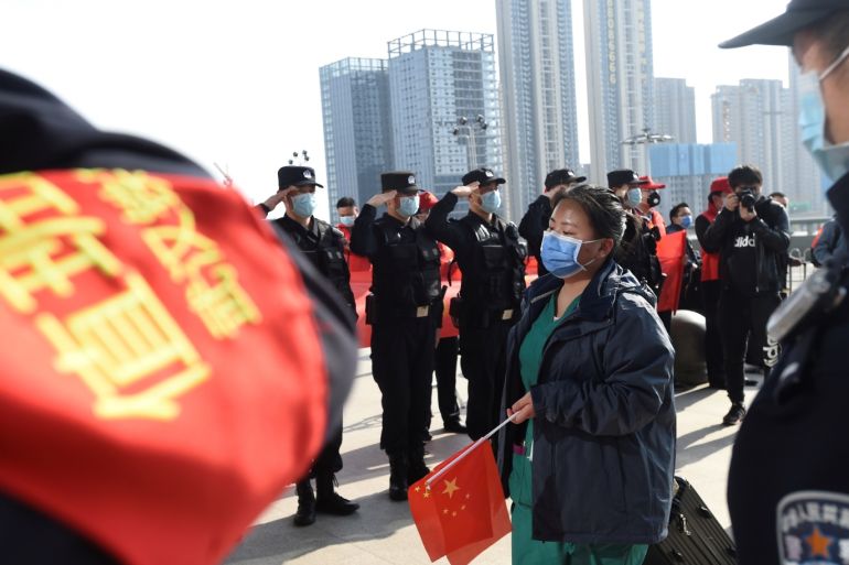 Police officers salute as a medical worker from outside Wuhan arrives at the Wuhan Railway Station before leaving the epicentre of the novel coronavirus disease (COVID-19) outbreak, in Hubei province, China March 17, 2020. Picture taken March 17, 2020. REUTERS/Stringer CHINA OUT. TPX IMAGES OF THE DAY
