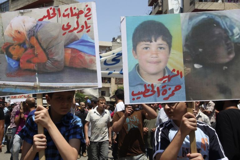 A protester (R) holds a placard with a picture of 13-year-old Syrian boy Hamza al-Khatib, who activists say was tortured and killed by security forces, as another carries a placard reading, "May you rest in heaven, my son" during a demonstration organised by Lebanese and Syrians living in Lebanon, to express solidarity with Syria's anti-government protesters, after the Friday prayers in Tripoli, northern Lebanon, June 24, 2011. REUTERS/ Mohamed Azakir (LEBANON - Tags: CIVIL UNREST POLITICS)