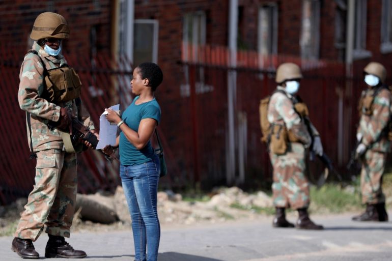 A member of the South African National Defence Force checks documents of a resident as they patrol in an attempt to enforce a 21 day nationwide lockdown, aimed at limiting the spread of coronavirus disease (COVID-19), in Alexandra township, South Africa, March 28, 2020. REUTERS/Siphiwe Sibeko