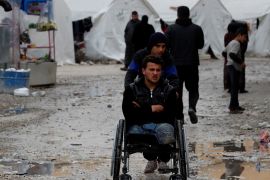 Internally displaced Syrian is pushed in a wheelchair along the tents in an IDP camp located in Idlib, Syria February 27, 2020. REUTERS/Umit Bektas