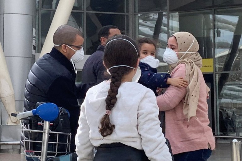 Parents wearing protective face mask hug their children upon their arrival, at Cairo International Airport (CAI) as Egypt ramps up its efforts to slow the spread the coronavirus disease (COVID-19) in Cairo, Egypt March 19, 2020. REUTERS/Amr Abdallah Dalsh