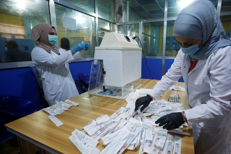 Iraqi doctors stick labels on locally made testing components for the coronavirus disease (COVID-19), as it's produced by a group of researchers from Basra University, in Basra, Iraq March 29, 2020. Picture taken, March 29, 2020. REUTERS/Essam Al-Sudani