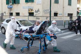 Medical staff in full protective gear carry a patient on a stretcher down a street in Naples, as the spread of coronavirus disease (COVID-19) continues, Italy, April 2, 2020. REUTERS/Ciro De Luca