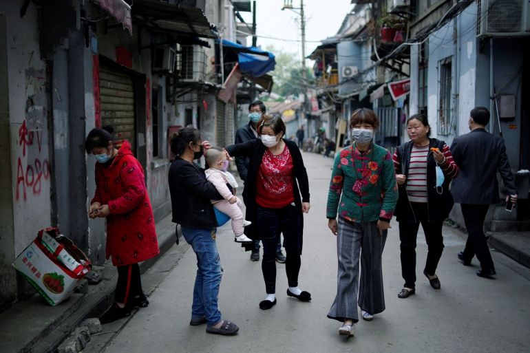 Residents wearing face masks walk at an old residential community blocked by barriers in Wuhan, Hubei province, the epicentre of China's coronavirus disease (COVID-19) outbreak, April 5, 2020. REUTERS/Aly Song