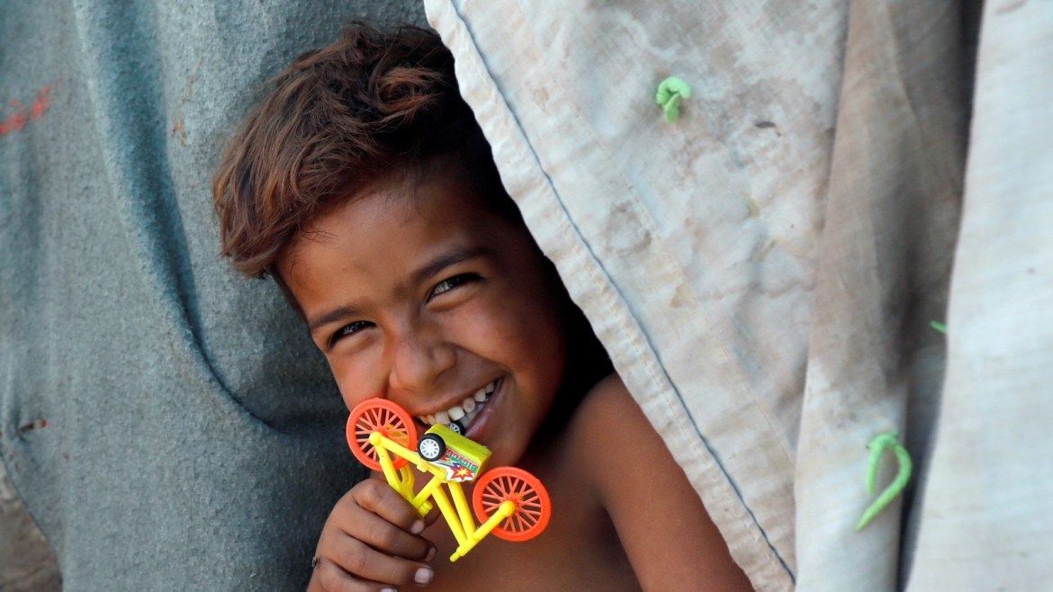 A boy plays with a toy outside his family tent in a slum, during a lockdown amid the outbreak of the coronavirus disease (COVID-19), in Karachi, Pakistan April 2, 2020. REUTERS/Akhtar Soomro