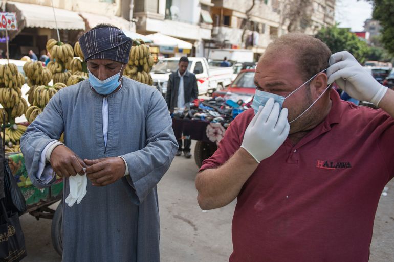 epa08307088 People wear protective masks during the initiative 'we can' to sterilize poor people in the streets, to protect themselves and increase of their awareness about coronavirus in Cairo, Egypt, 19 March 2020. EPA-EFE/Mohamed Hossam