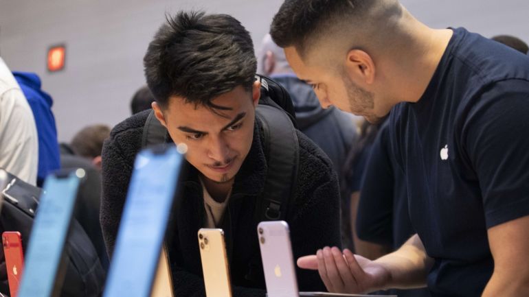 NEW YORK, NY - SEPTEMBER 20: An Apple employee helps a customers shop for the new iPhone 11 at Apple's flagship 5th Avenue store on September 20, 2019 in New York City. Apple's new iPhone 11 goes on sale today at the grand re-opening of the 5th Avenue store. Drew Angerer/Getty Images/AFP== FOR NEWSPAPERS, INTERNET, TELCOS & TELEVISION USE ONLY ==