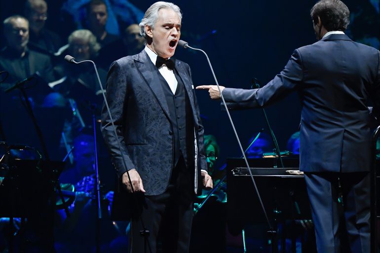 epa08002290 Italian opera singer Andrea Bocelli (L) performs with a choir and a symphonic orchestra lead by Italian conductor Marcello Rota (R) during a concert at the Papp Laszlo Sports Arena in Budapest, Hungary, 16 November 2019. EPA-EFE/Szilard Koszticsak HUNGARY OUT