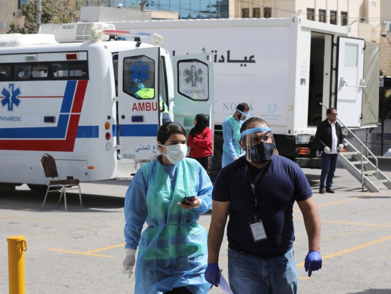 Jordanian doctors walk next to the mobile clinics that are operated as part of initiative that was launched with the aim of providing Jordanians with field medical services, amid concerns over the spread of the coronavirus disease (COVID-19), in Amman, Jordan, March 30, 2020. Picture taken March 30, 2020. REUTERS/Muhammad Hamed