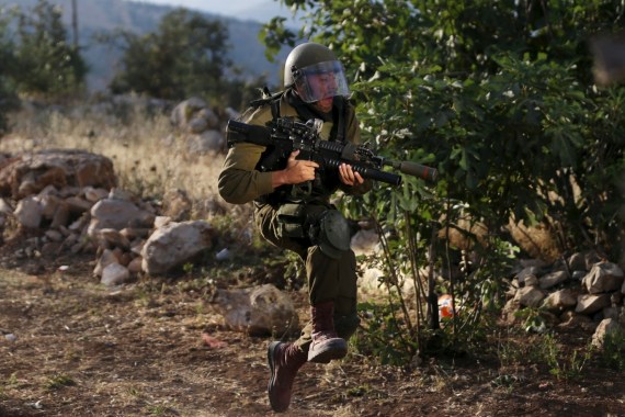 An Israeli soldier reacts as he runs during clashes with Palestinian protesters at a protest against the Jewish settlement of Ofra, in the West Bank village of Silwad, near Ramallah June 5, 2015. REUTERS/Mohamad Torokman TPX IMAGES OF THE DAY