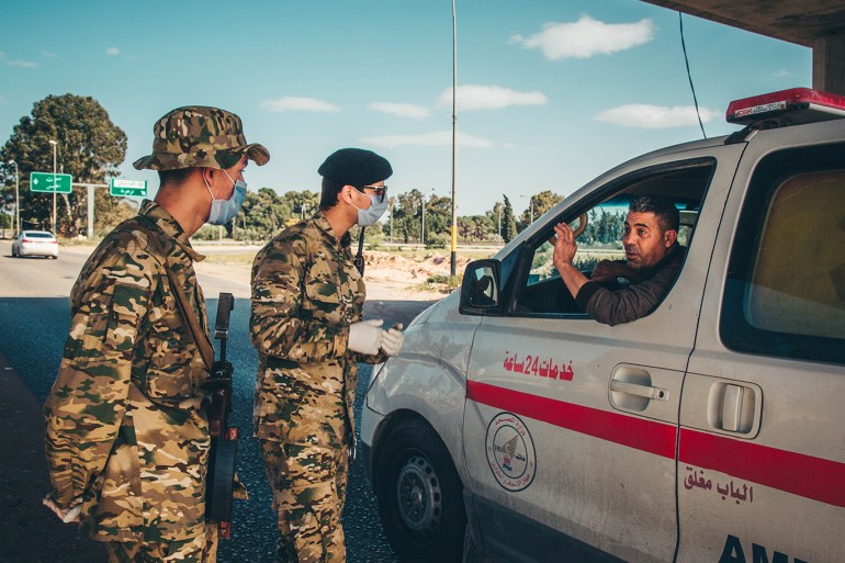 سيارة إسعاف تمر على نقطة أمنية في طرابلس