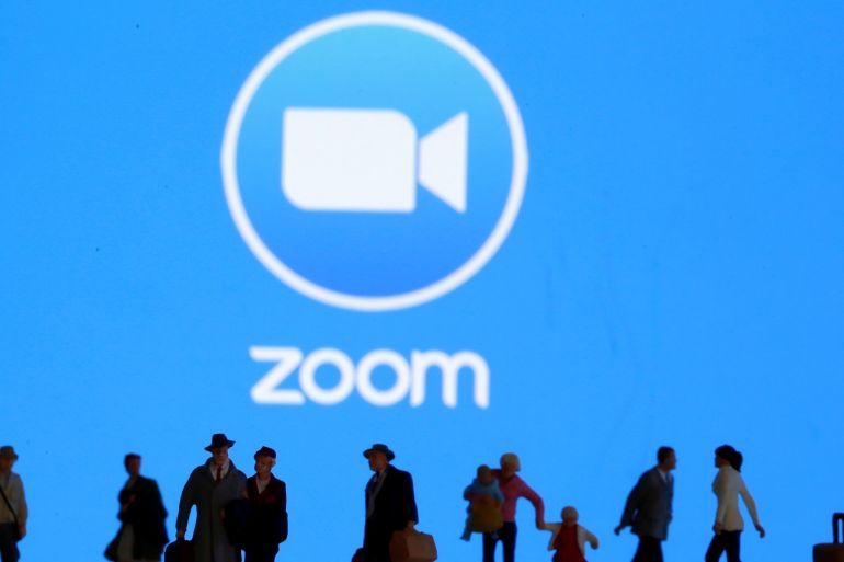 Small toy figures are seen in front of diplayed Zoom logo in this illustration taken March 19, 2020. REUTERS/Dado Ruvic/Illustration