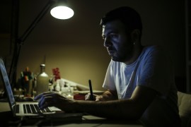 Lives Without Televisions- - ANKARA, TURKEY - OCTOBER 24 : Deniz Guler, a graphic designer, spends time on his computer at his home in Ankara, Turkey on October 24, 2018. Guler says ; He doesn't need a Tv to access information, using a computer is enough for that. Guler reads books and spends time on the computer in his spare times. For many people televisions have been a must have house material since its invention in 1923, but for some people in 20th century prefer to live without it. Television lost its significance following the rise of the internet, websites, social media and mobile phones, as these innovations offer a global accessibility with freedom of choice.