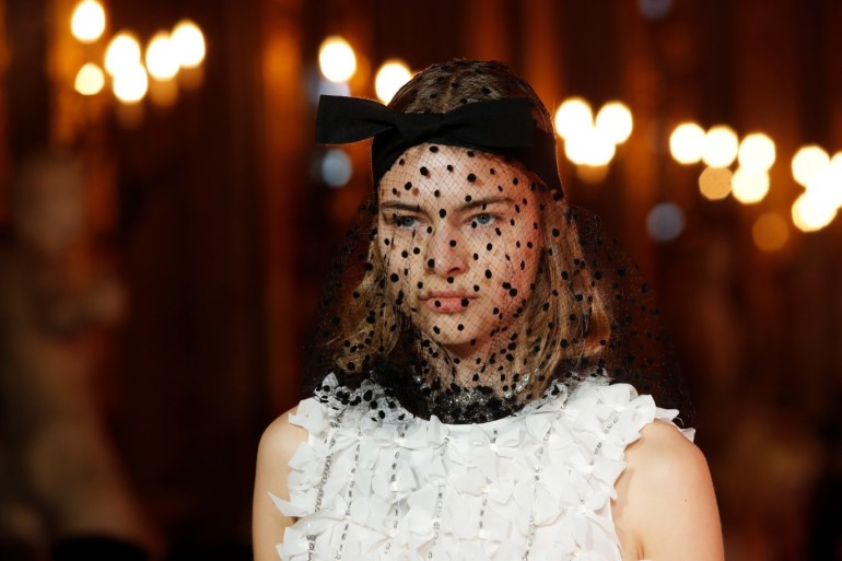 A model wears a black veiled fascinator with bow and a sleeveless white silk adorned top, at the Giambattista Valli fashion show, where the designer presented his collection created in collaboration with fast-fashion giant H&M, in Rome, Italy October 24, 2019. Picture taken October 24, 2019. REUTERS/Remo Casilli