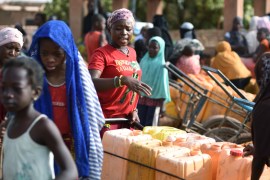 People wait for their turn to buy water from a privately-owned water tower, amid an outbreak of the coronavirus disease (COVID-19), in Taabtenga district of Ouagadougou, Burkina Faso April 3, 2020. Picture taken April 3, 2020. REUTERS/Anne Mimault