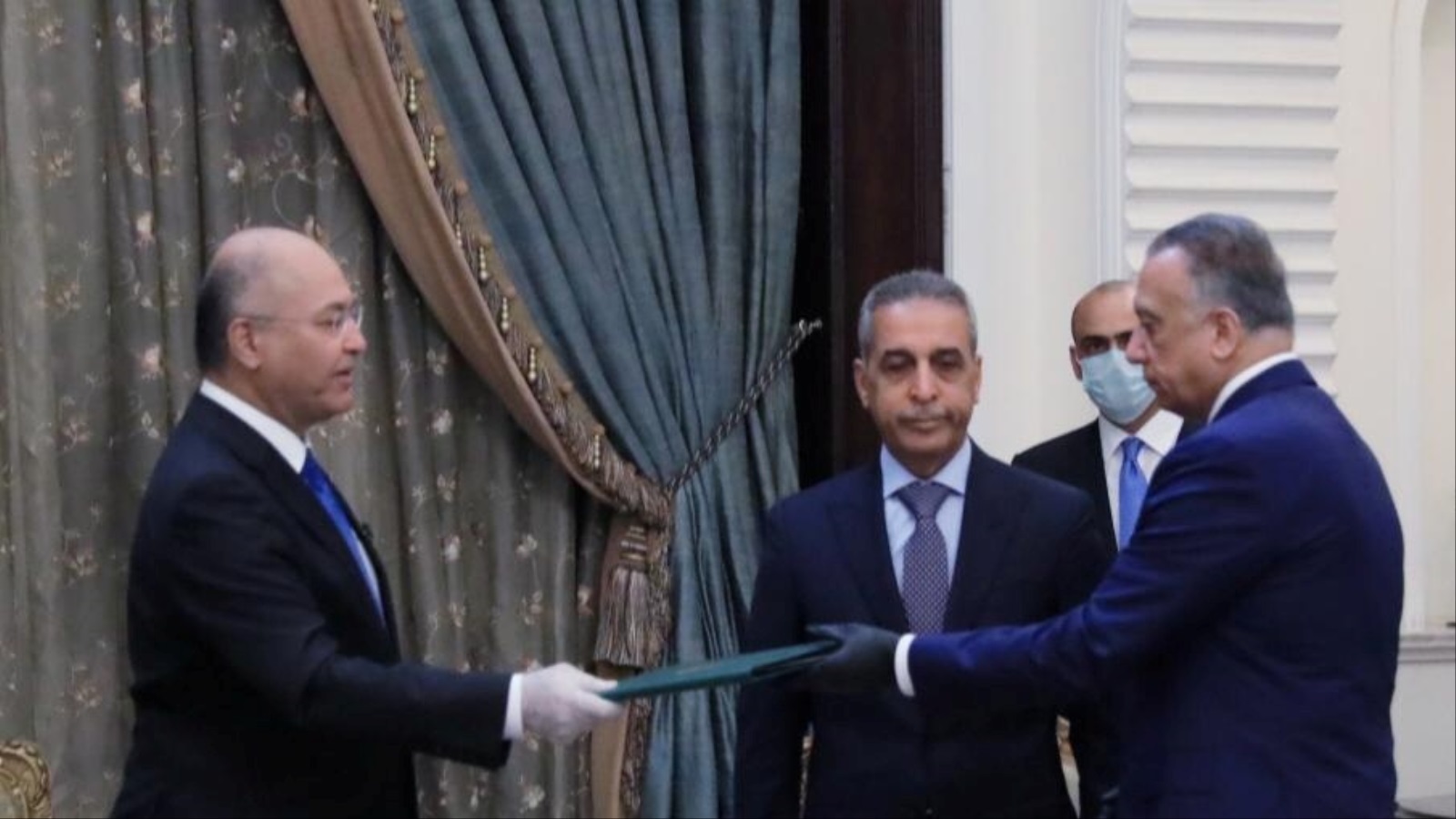 الرئيس العراقي برهم صالح (يسار) لدى تكليفه الكاظمي برئاسة الوزراء (رويترز)