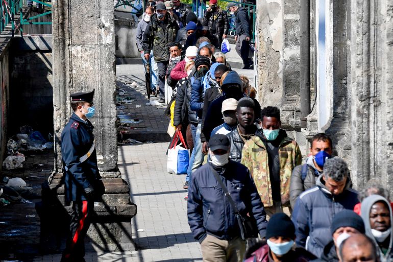epa08342602 The Carabinieri maintain order among the many people lined up at the soup kitchen of the 'Carmine Maggiore' church in Naples, Italy, 04 April 2020. In the aftermath of the Covid-19 pandemic, many canteens for the poor have been closed and those that are open must feed many more people. EPA-EFE/CIRO FUSCO