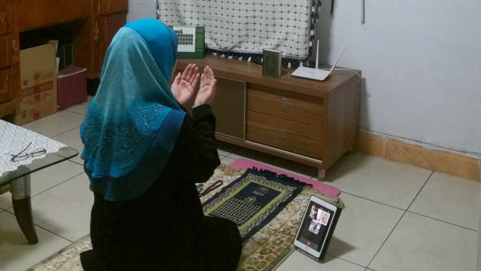 ‪صينية مسلمة خلال أداء صلاة التراويح في المنزل‬ (الجزيرة)