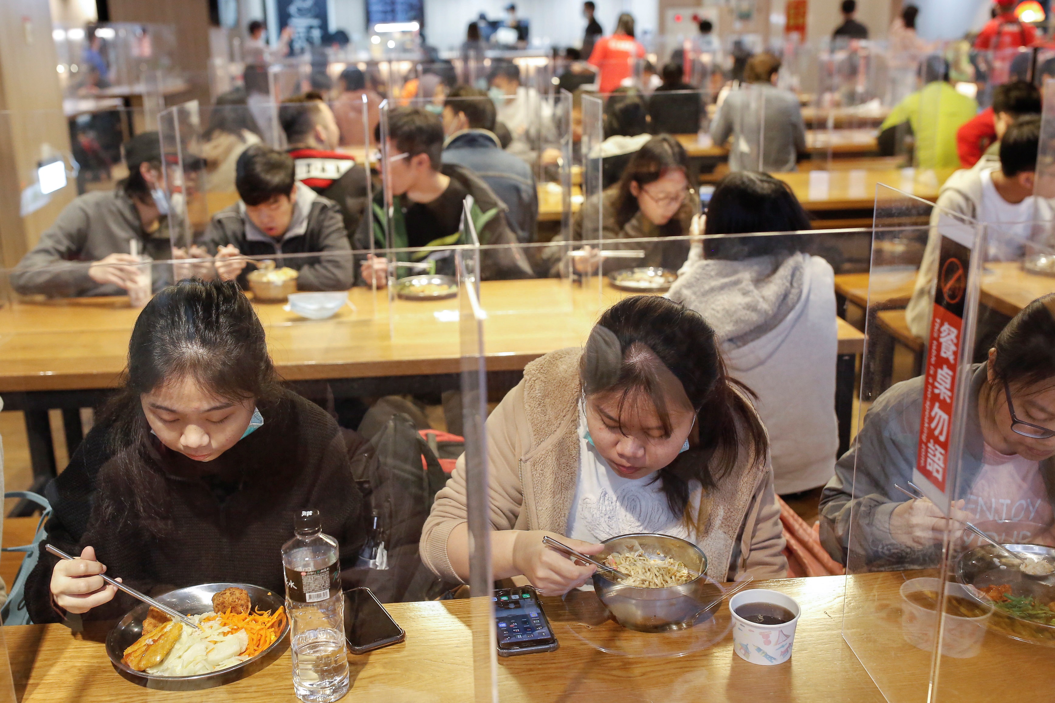 الطلاب يتناولون طعام الغداء بين الفواصل لحمايتهم من مرض فيروس كورونا في مقصف جامعة تايوان الوطنية للعلوم والتكنولوجيا في تايبيه (رويترز)