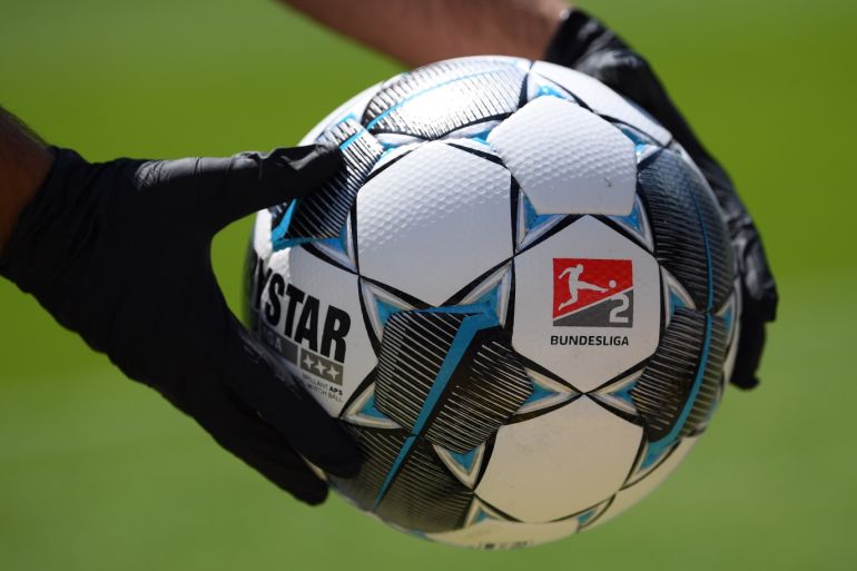 KARLSRUHE, GERMANY - MAY 16: A ball boy wearing protective gloves holds an official Derbystar match ball prior to the Second Bundesliga match between Karlsruher SC and SV Darmstadt 98 at Wildparkstadion on May 16, 2020 in Karlsruhe, Germany. The Bundesliga and Second Bundesliga is the first professional league to resume the season after the nationwide lockdown due to the ongoing Coronavirus (COVID-19) pandemic. All matches until the end of the season will be played behind closed doors. (Photo by Matthias Hangst/Getty Images )
