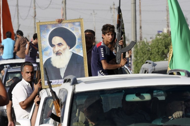 Volunteers, who have joined the Iraqi Army to fight against predominantly Sunni militants, carry weapons and a portrait of Grand Ayatollah Ali al-Sistani during a parade in the streets in Baghdad's Sadr city June 14, 2014. An offensive by insurgents that threatens to dismember Iraq seemed to slow on Saturday after days of lightning advances as government forces regained some territory in counter-attacks, easing pressure on the Shi'ite-led government in Baghdad. REUTERS/Wissm al-Okili (IRAQ - Tags: CIVIL UNREST POLITICS MILITARY RELIGION)