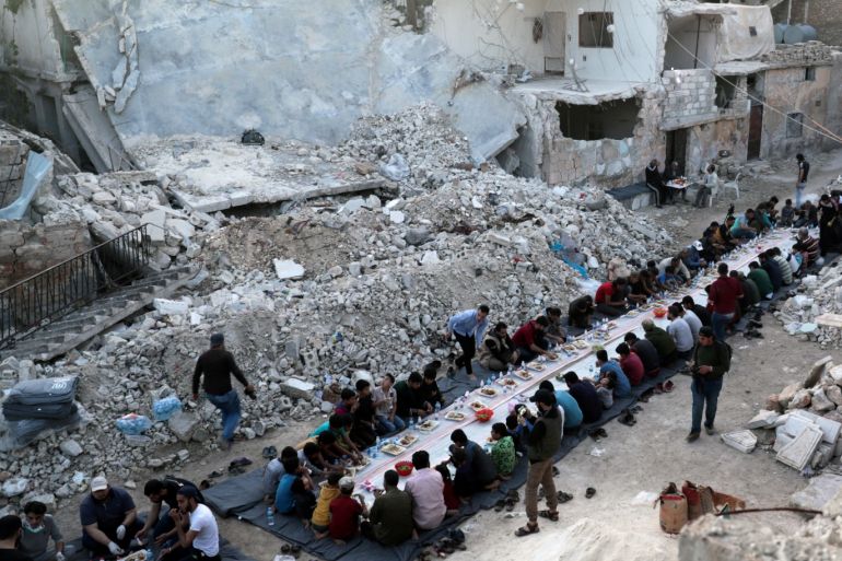 People eat their Iftar meal provided by a group of volunteers in a damaged neighbourhood, amid fear for the coronavirus disease (COVID-19) outbreak, in Atarib, Aleppo countryside, Syria, May 7, 2020. REUTERS/Khalil Ashawi TPX IMAGES OF THE DAY