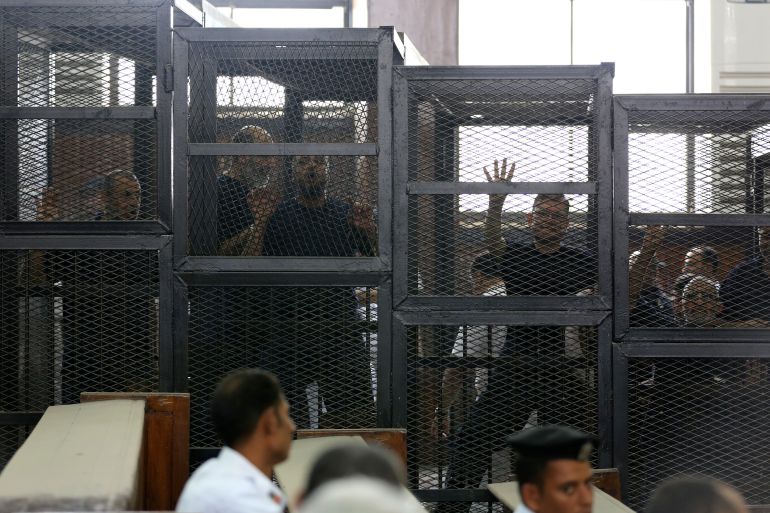 Muslim Brotherhood's General Guide Mohamed Badie is pictured in a defendant's cage with other defendants in a courtroom in Cairo