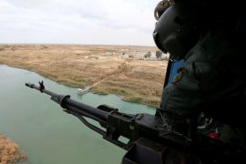 Member of Iraqi security forces is seen in a helicopter during military operations to search for IS militants in Anbar province