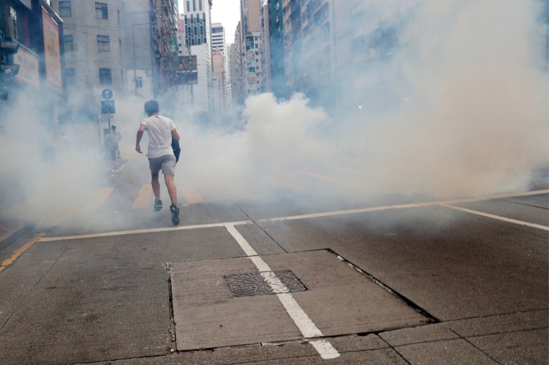 Anti-government protester runs away from tear gas in Hong Kong