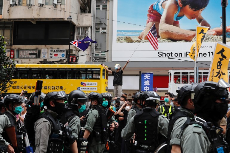 Anti-government protester waves U.S. and British Hong Kong flags in Hong Kong