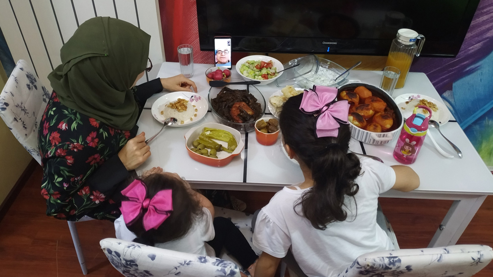 ‪عائلة خلود تتواصل مع والدها عبر اتصال فيديو في موعد الافطار‬ (الجزيرة)