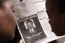 Readers look at a newspaper June 12, 2002 in Nairobi carrying the photograph of Rwandan Felicien Kabuga wanted by the United States. The United States stepped up a search for the alleged masterminds of Rwanda's 1994 genocide on Tuesday by publishing a "wanted" photograph in Kenyan newspapers of the wealthy Rwandan accused of helping finance the killings. REUTERS/George Mulala GMM/WS